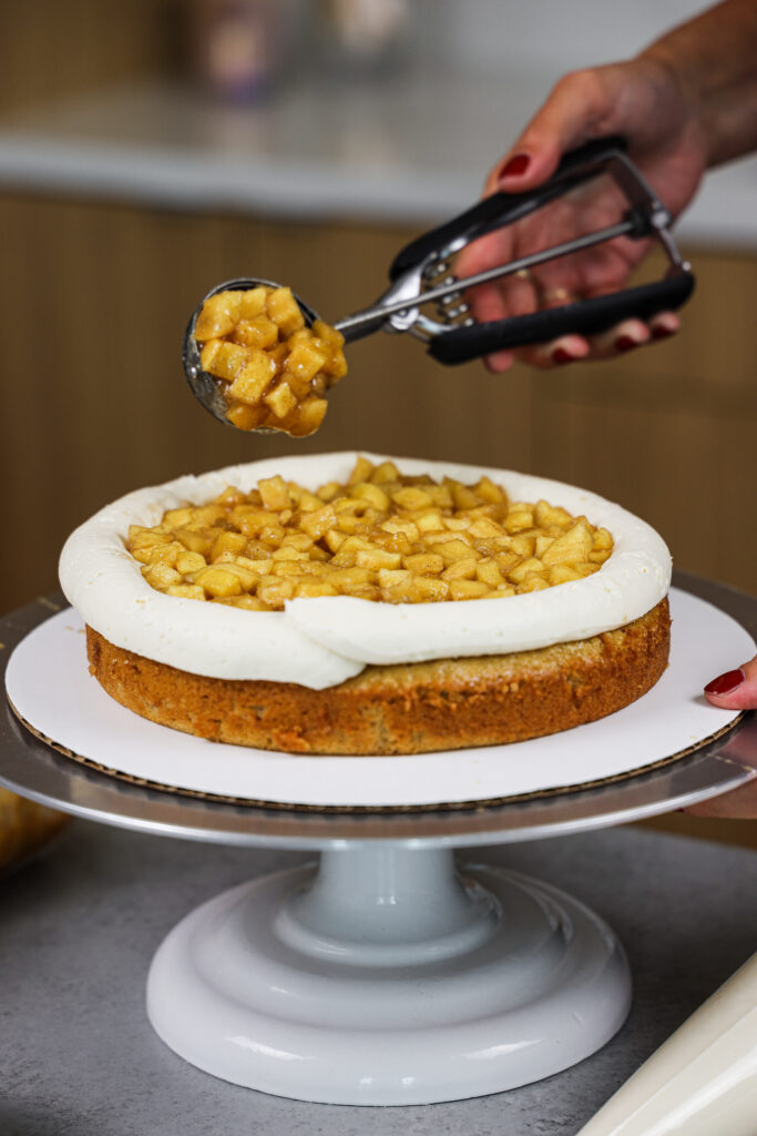 image of apple cake filling being added to a spice cake