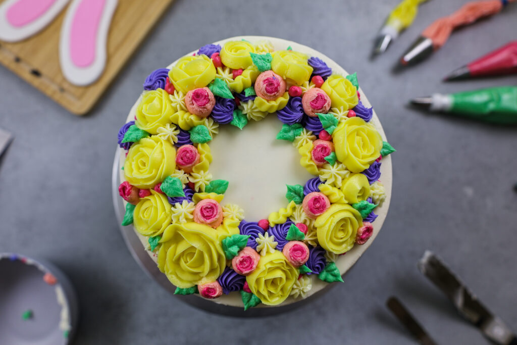 image of buttercream flowers piped in a ring on top a bunny rabbit cake to make a flower crown