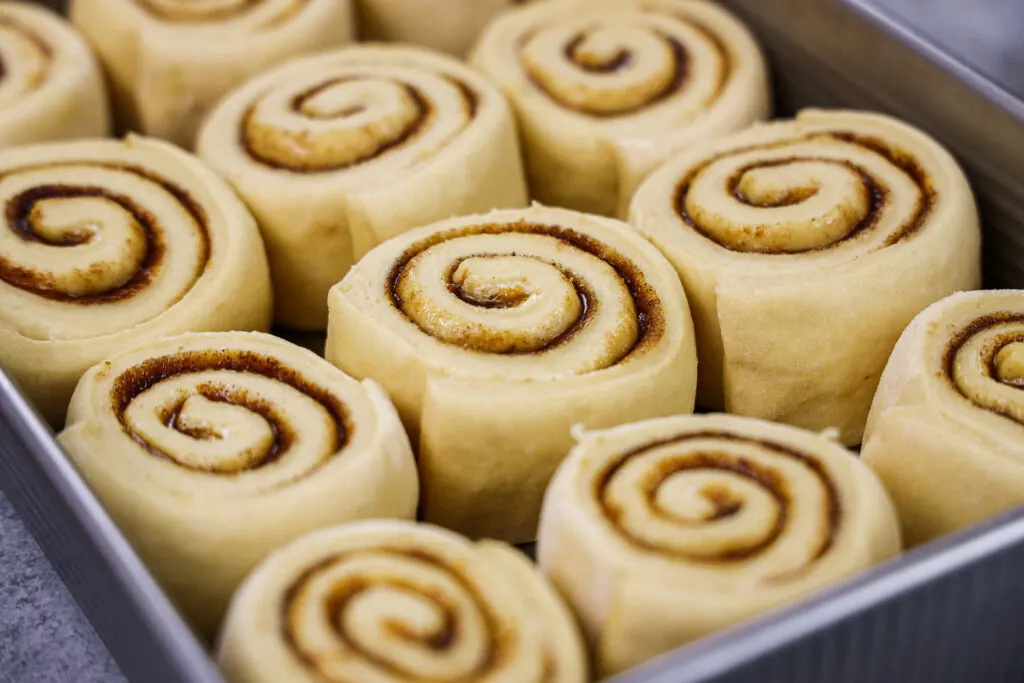 image of pumpkin pie cinnamon rolls that have proofed and are ready to be baked
