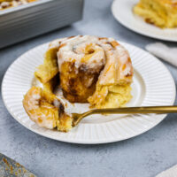 image of a pumpkin pie cinnamon roll that's been cut into to show how soft and tender it is