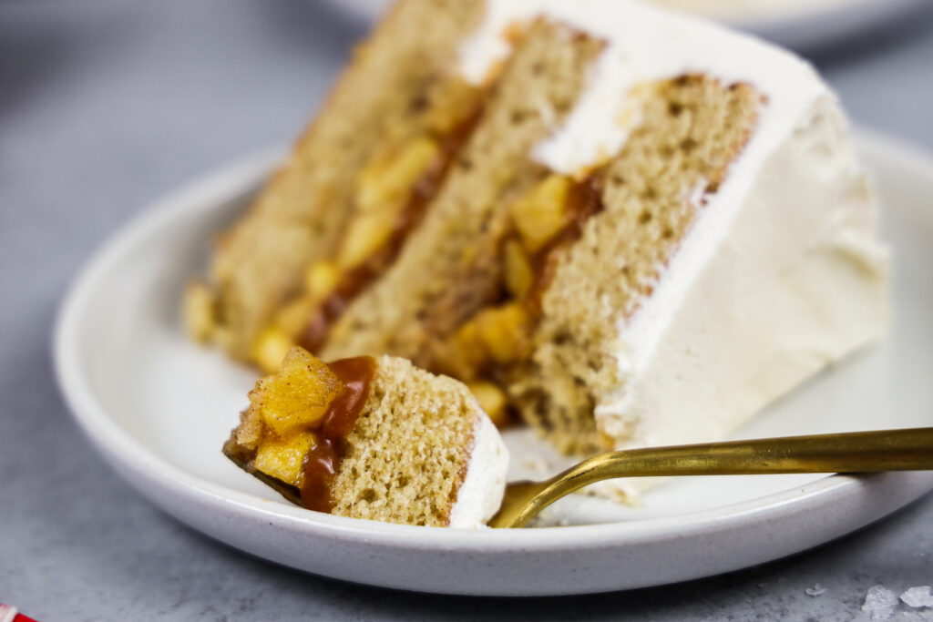 image of a slice of salted caramel apple cake on plate filled with apple cake filling