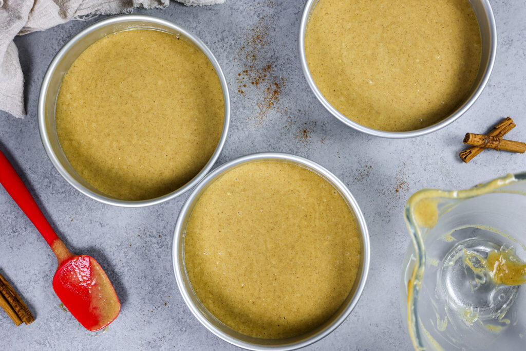 image of spice cake batter in 8 inch cake pans ready to be baked