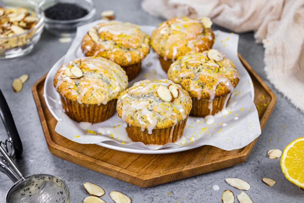 image of almond poppy seed muffins glazed with almond glaze sitting on a tray ready to be eaten