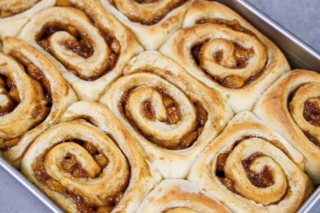 image of caramel apple cinnamon rolls that have been baked and are ready to be glazed
