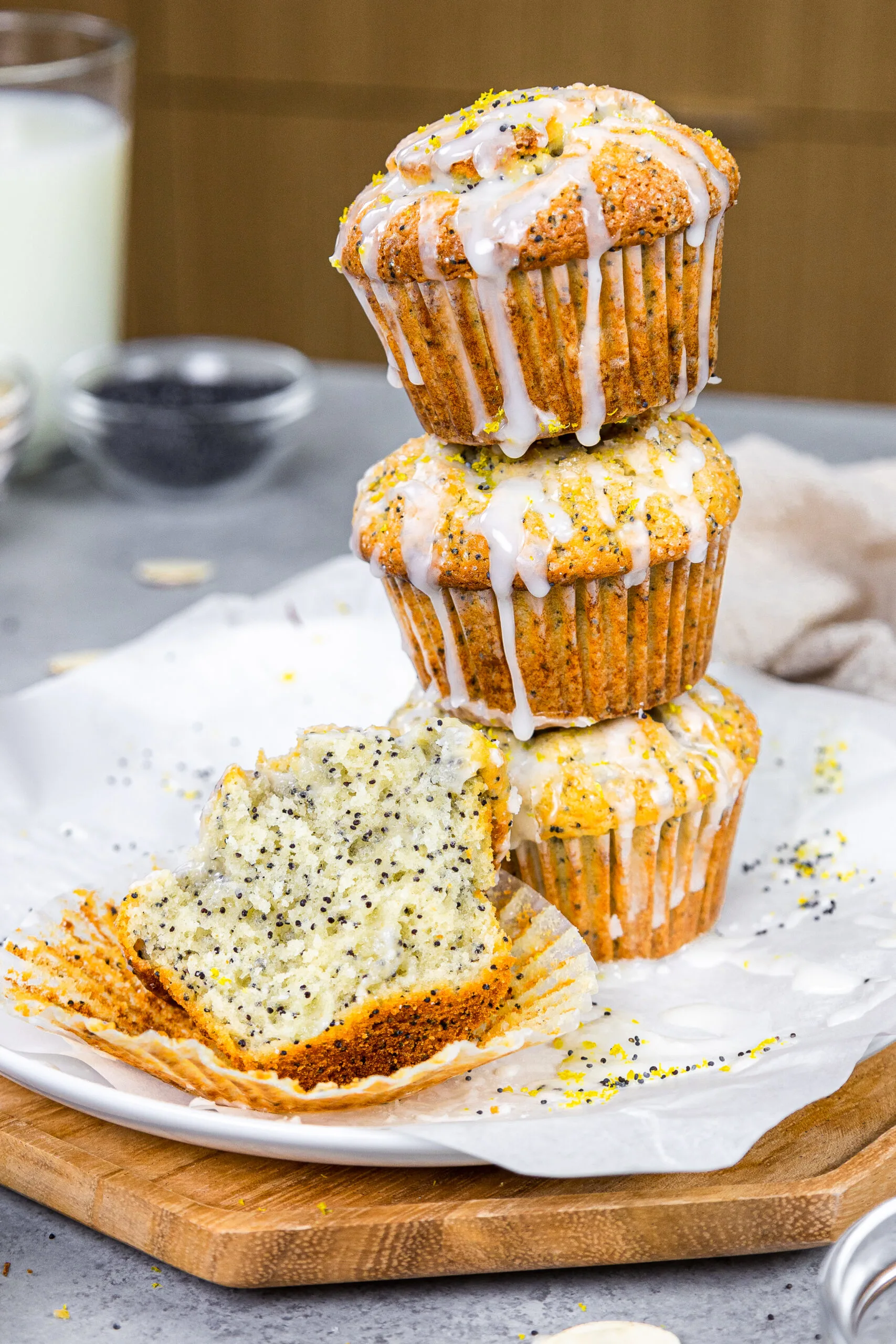 image of almond poppy seed muffins stacked with a muffin cut into to show how tender and soft it is
