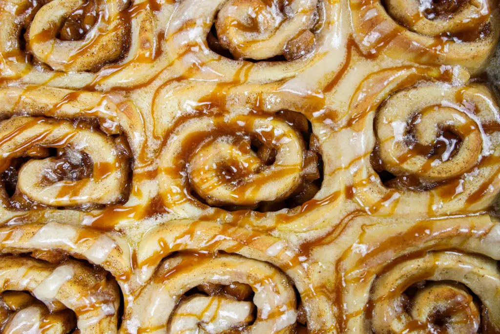 image of caramel apple cinnamon rolls that have been covered with a caramel glaze