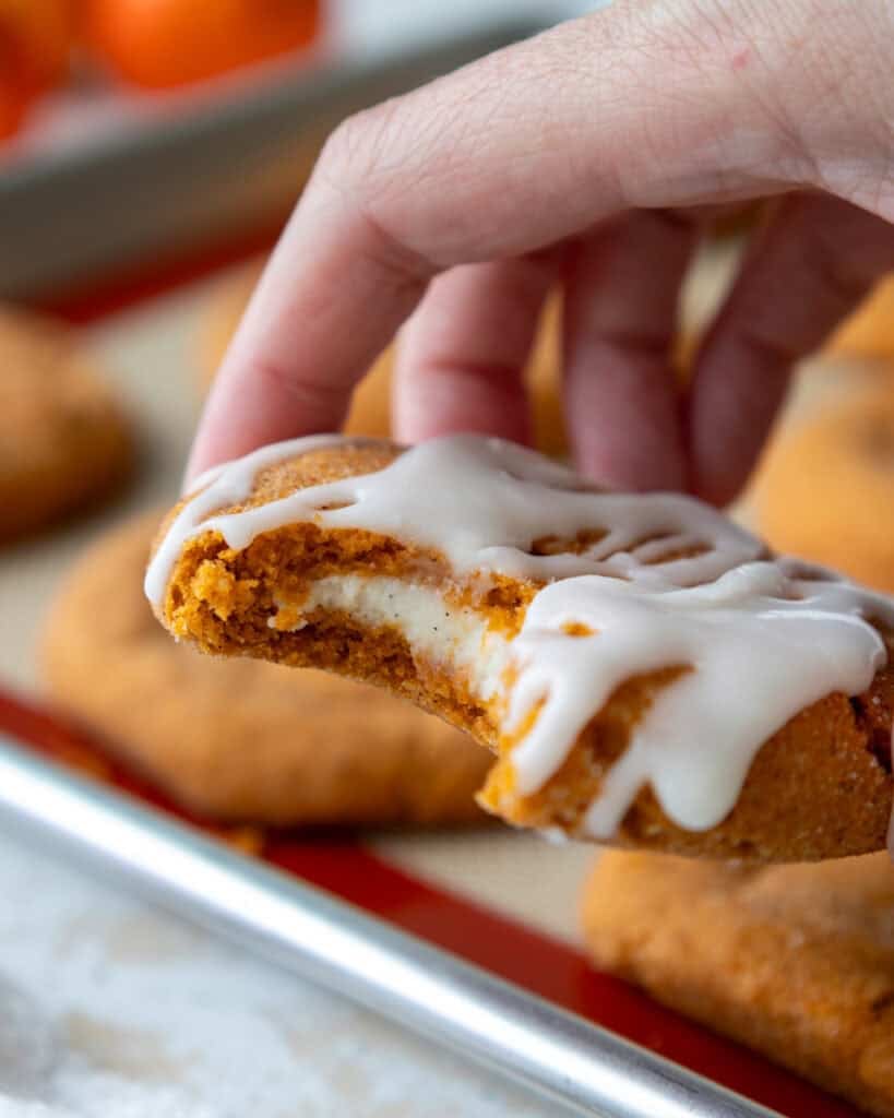 image of a pumpkin cheesecake cookie that's been drizzled with cream cheese glaze