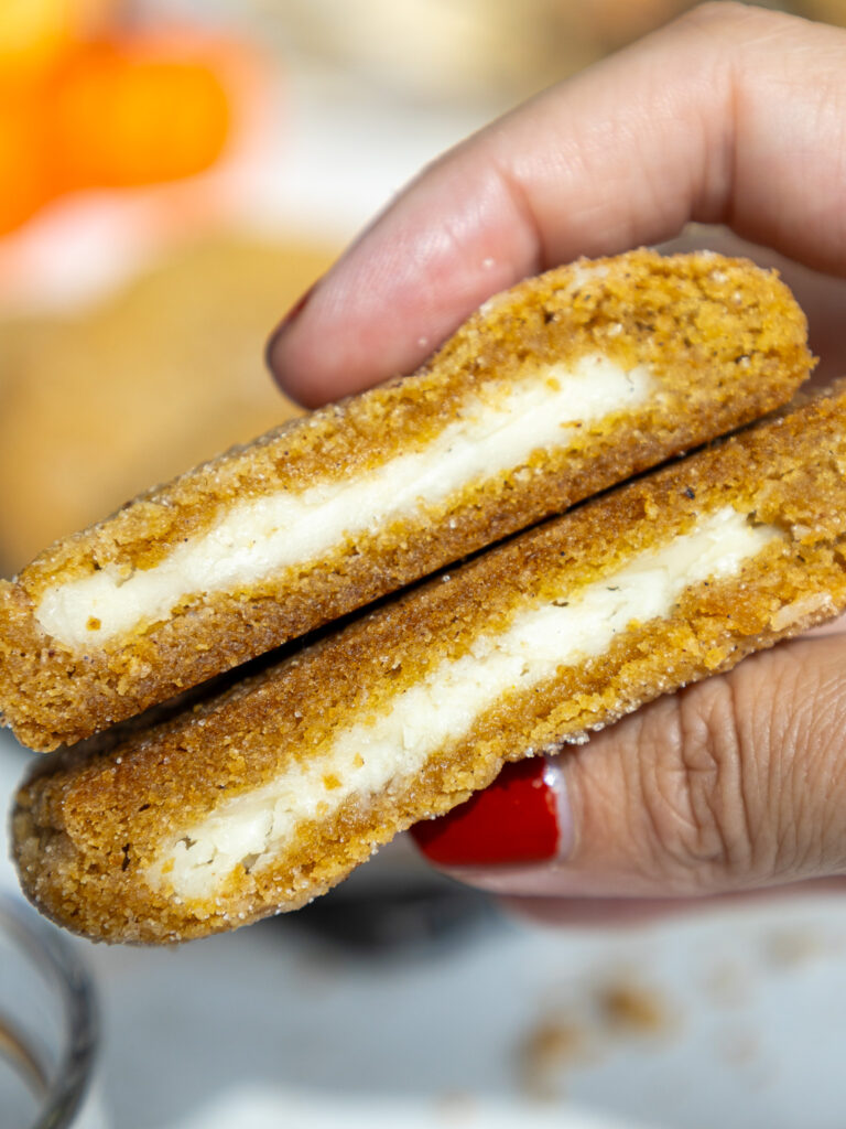 image of pumpkin cheesecake cookies that have been cut into to show their creamy cheesecake filling