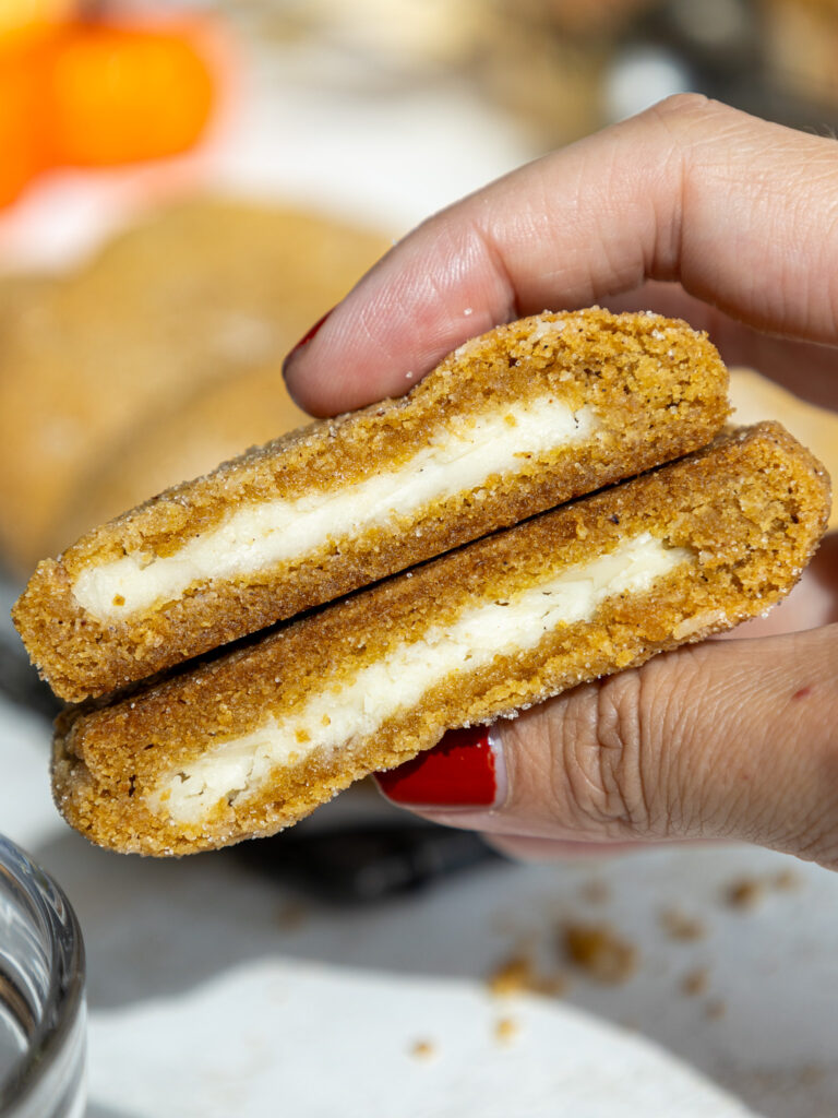 image of pumpkin cheesecake cookies that have been cut into to show their creamy cheesecake filling