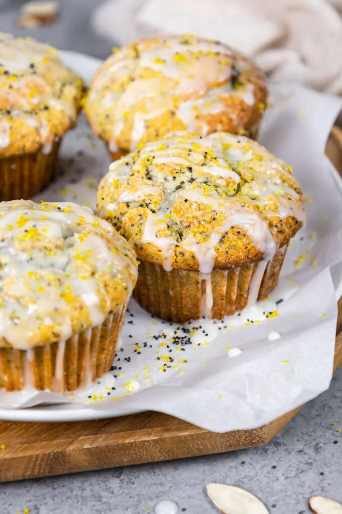 image of almond poppy seed muffins glazed with almond glaze sitting on a tray ready to eat