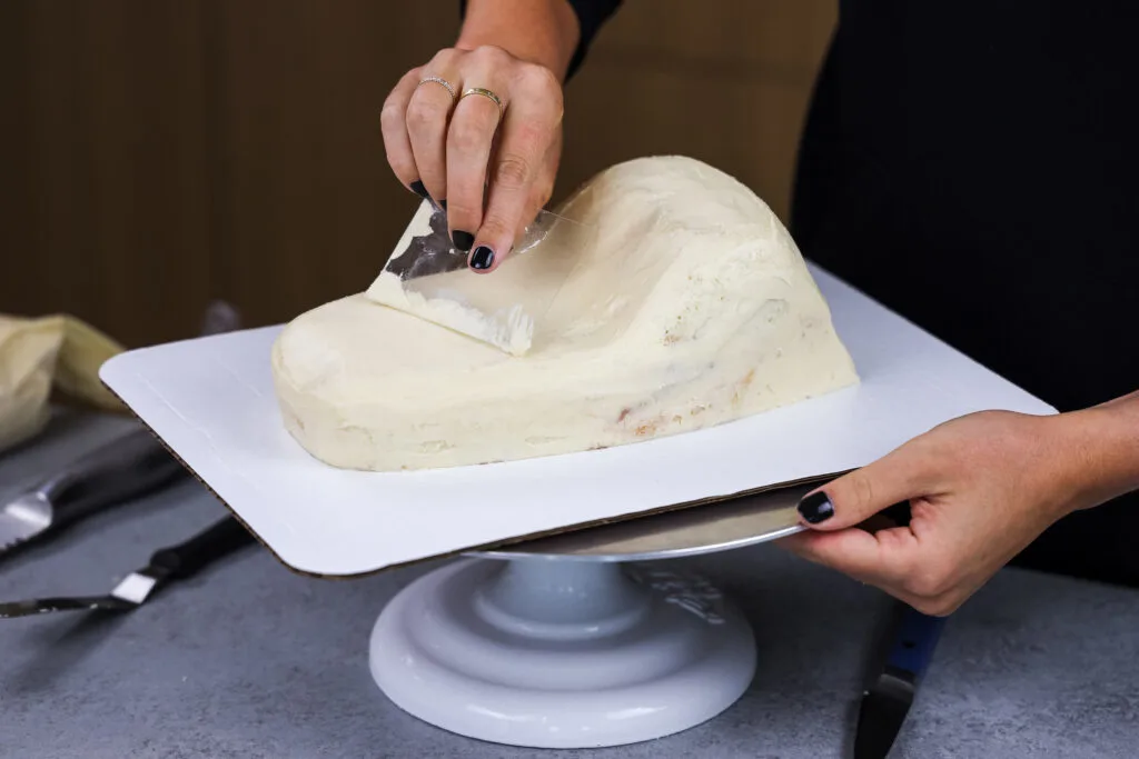 image of cake layers being crumb coated to make a crocodile or alligator cake