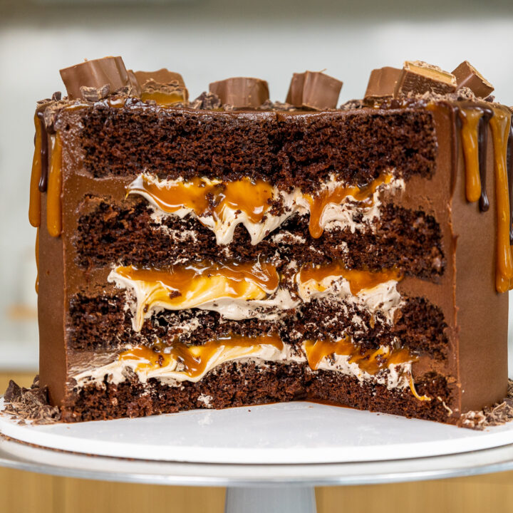 image of a cross section of a milky way that's been cut into to show its fluffy chocolate filling, homemade caramel filling, and moist chocolate cake layers