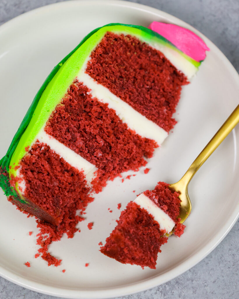 image of a slice of red velvet cake that's been cut into to show how soft and tender the cake layers are