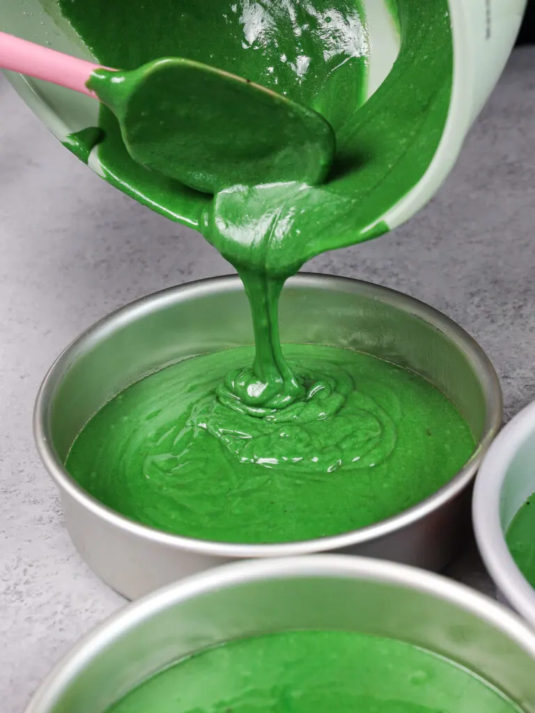 image of green velvet cake batter being poured into a 7 inch cake pan