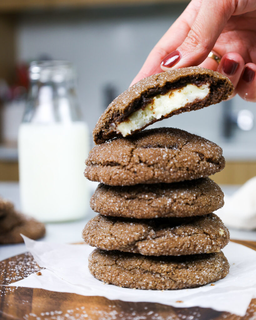 image of a chocolate cheesecake cooke that's been bitten into to show its creamy cheesecake filling