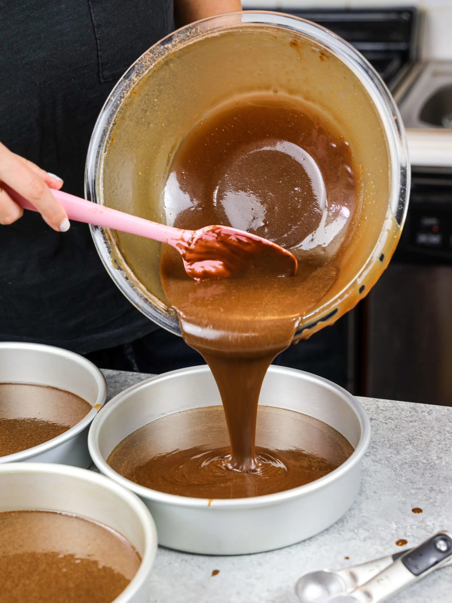 image of my moist chocolate cake batter being poured into 8 inch cake pans