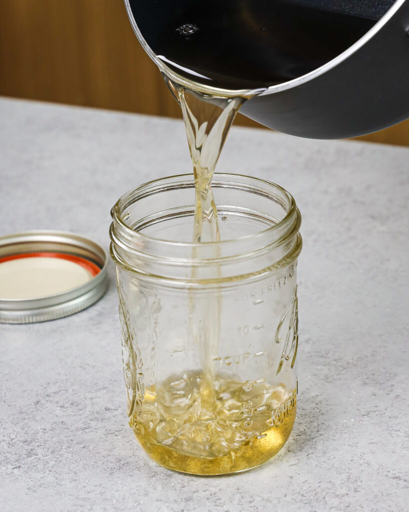 image of vanilla bean simple syrup being poured into a mason jar to be used to make cocktails and coffee later