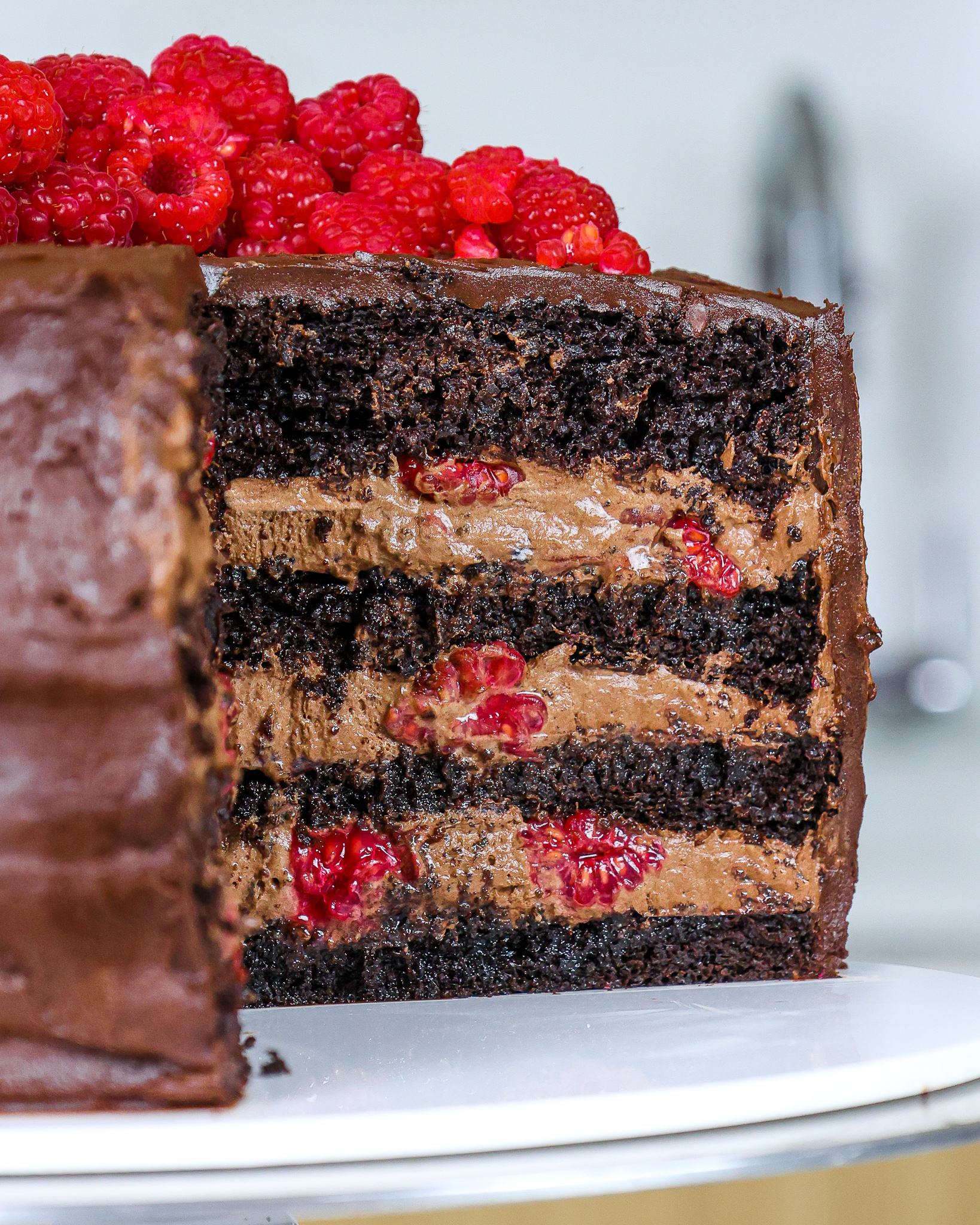 image of delicious chocolate raspberry mousse cake that's been cut into to show it's moist layers of chocolate cake and chocolate mousse filling