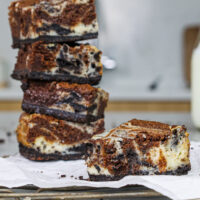 image of an oreo cheesecake brownie that's been bitten into to show it's swirls of chocolatey brownie and oreo cheesecake