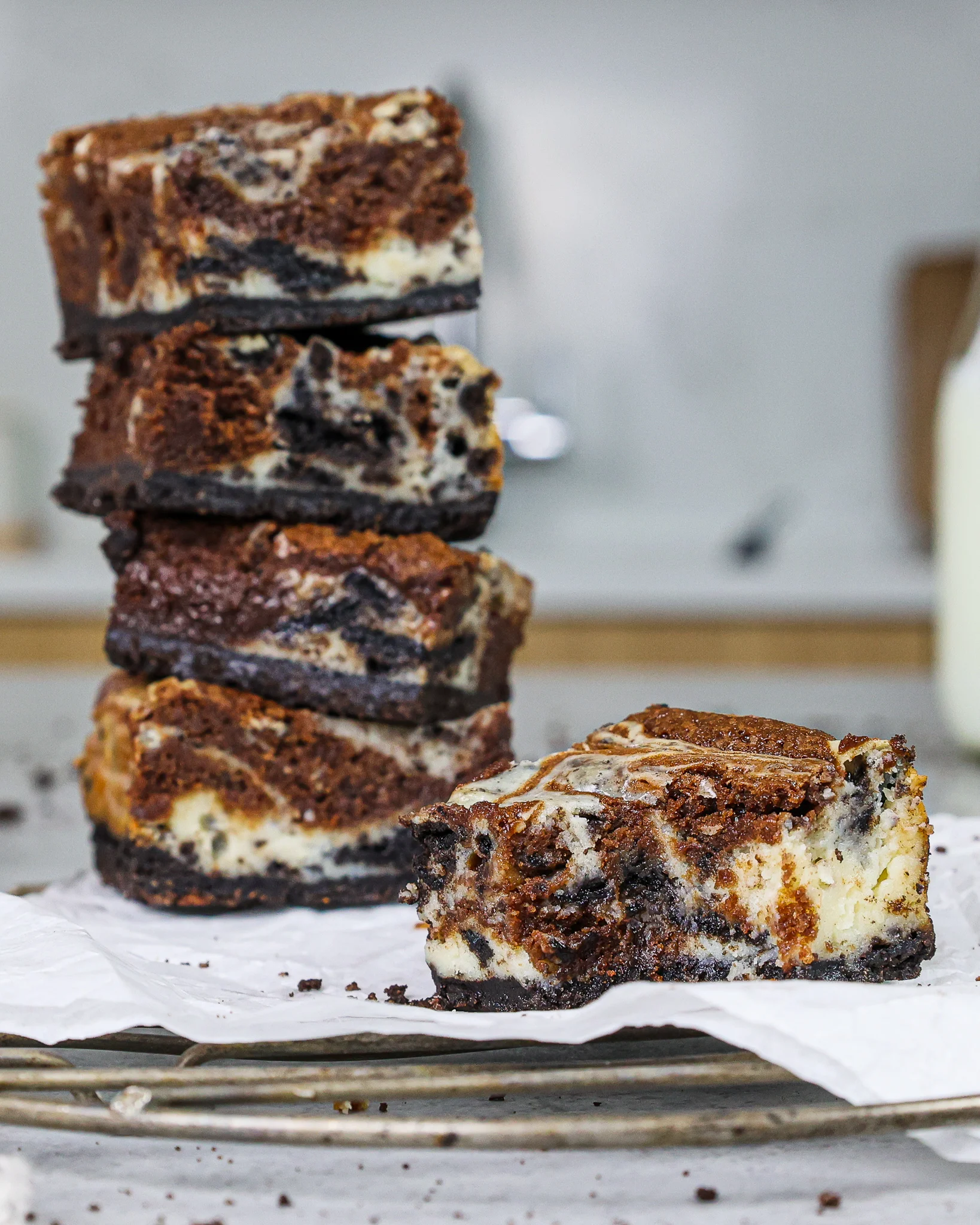 image of an oreo cheesecake brownie that's been bitten into to show it's swirls of chocolatey brownie and oreo cheesecake