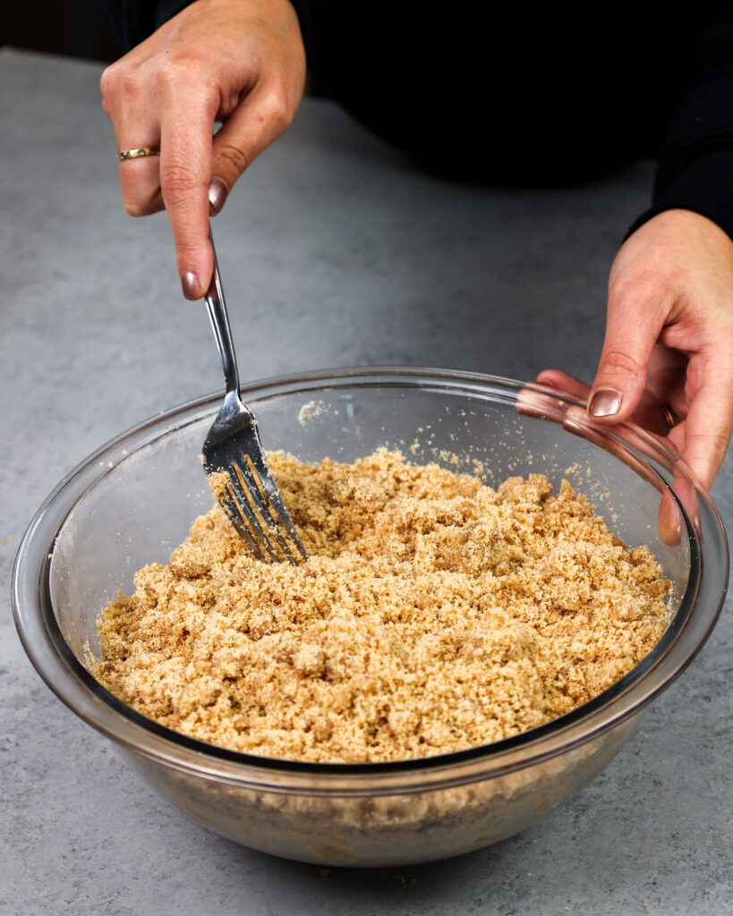 image of cinnamon streusel being stirred with a fork to keep the butter chunks intact and create a perfect crumbly streusel