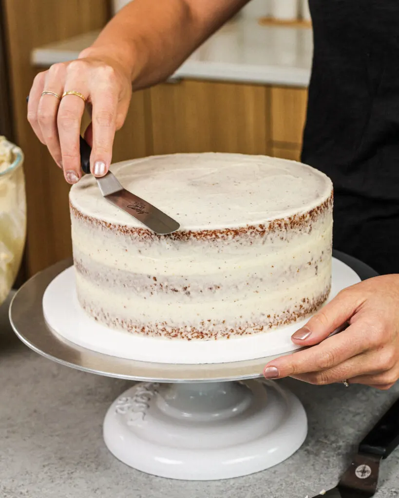 image of a layered coffee cake being crumb coated with brown butter frosting