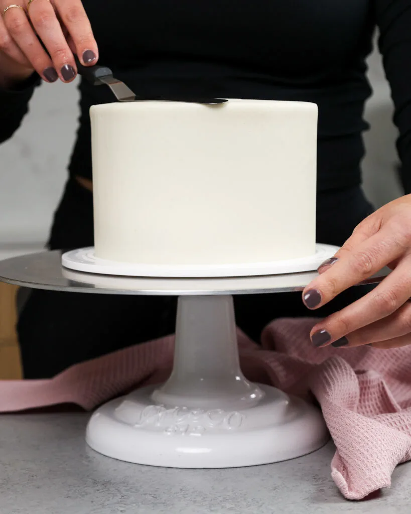 image of a 6-inch layer cake that's being frosted smoothly with vanilla buttercream frosting