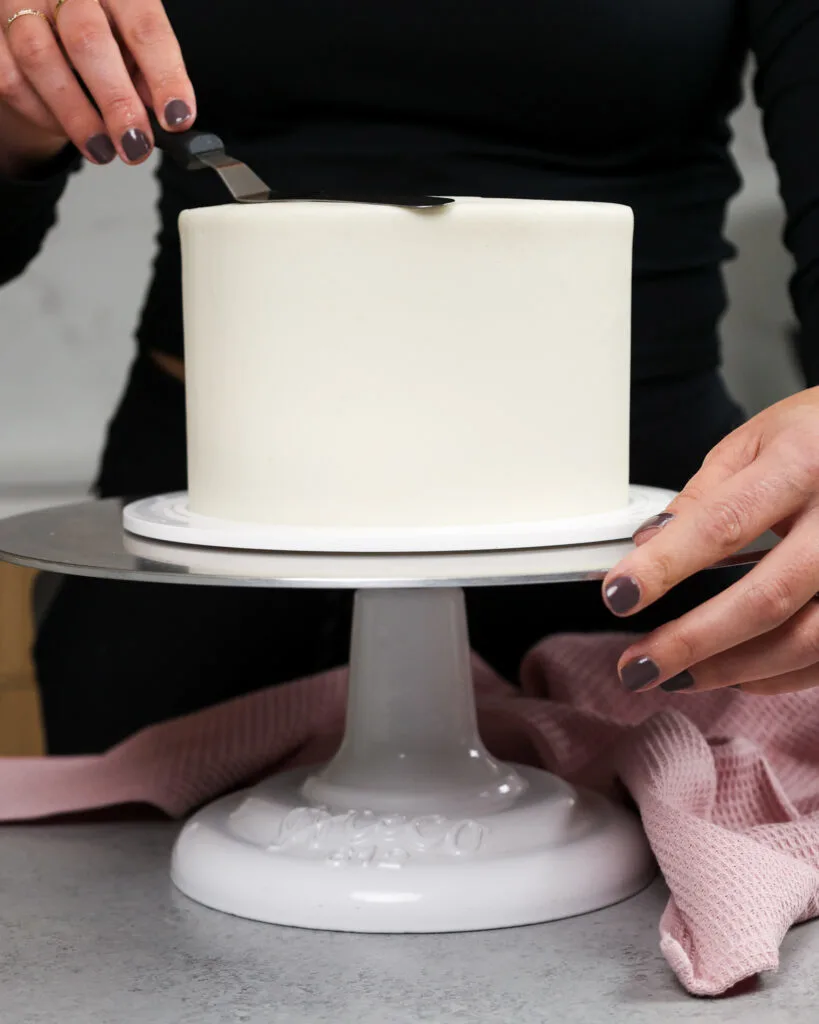 https://chelsweets.com/wp-content/uploads/2021/11/image-of-a-six-inch-cake-being-frosted-smoothly-with-buttercream-frosting-819x1024.jpg.webp