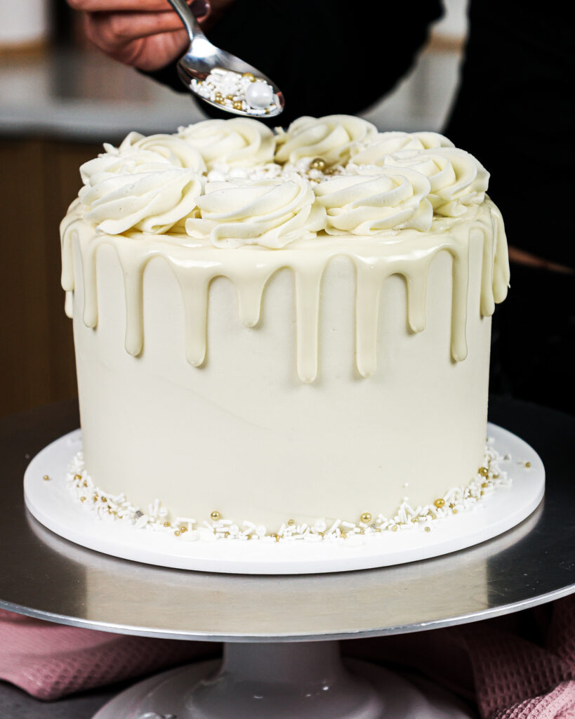image of sprinkles being added to a white drip cake