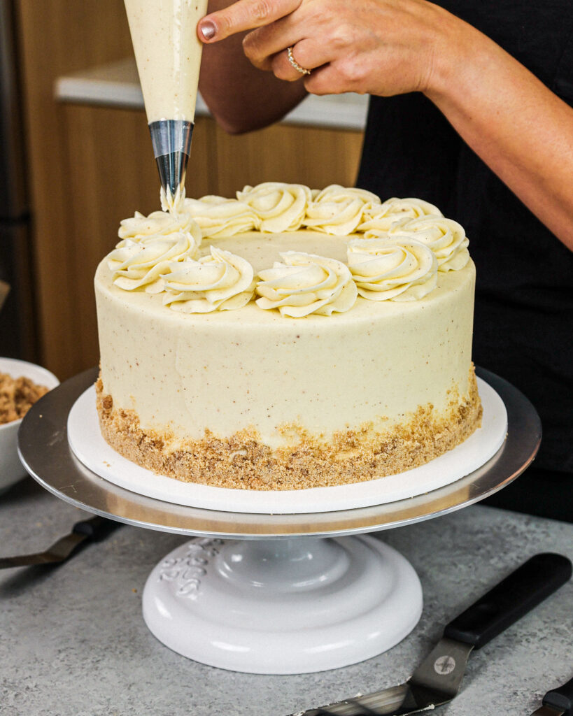 image of vanilla cake being frosted with brown butter buttercream frosting