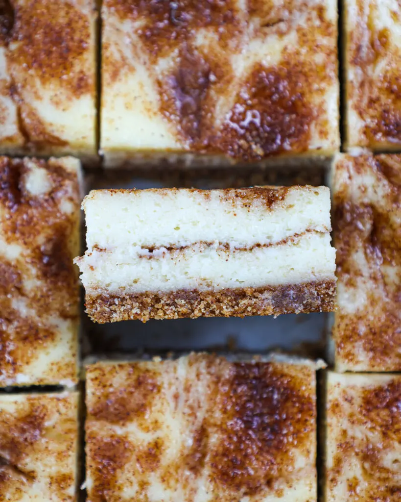 image of a snickerdoodle cheesecake bar that's been flipped on its side to show its cinnamon sugar swirl