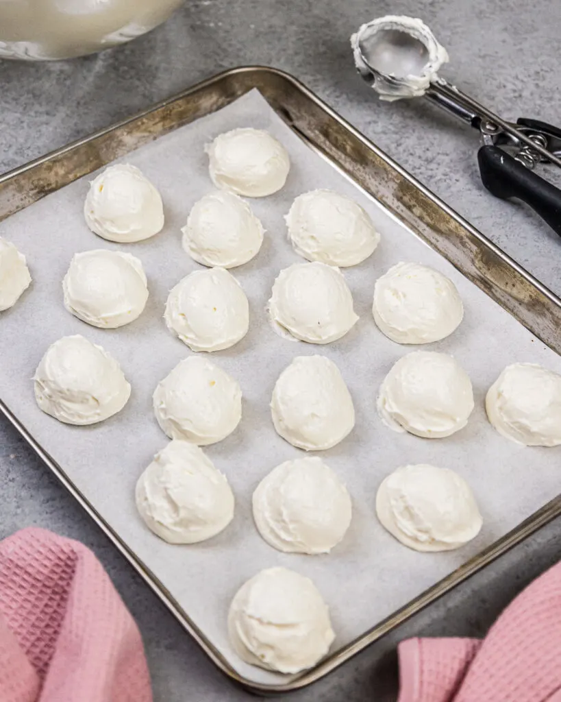 image of cheesecake scoops that have been placed on a piece of parchment paper to be frozen