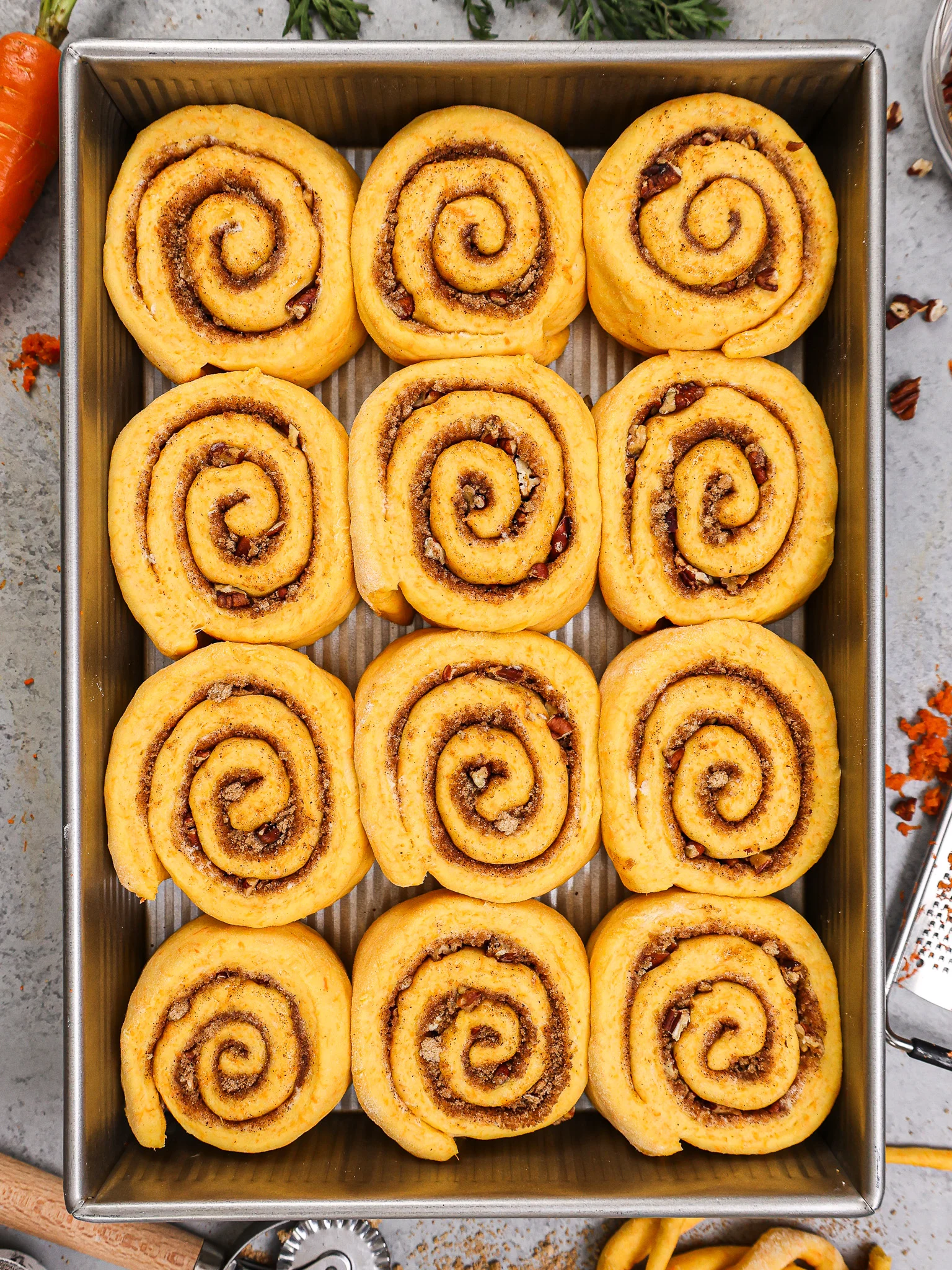 image of carrot cake cinnamon rolls that have been proofed and are ready to be baked