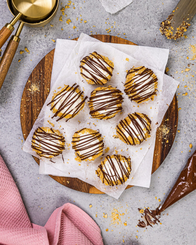 image of no bake cheesecake bites that have been drizzled with melted chocolate