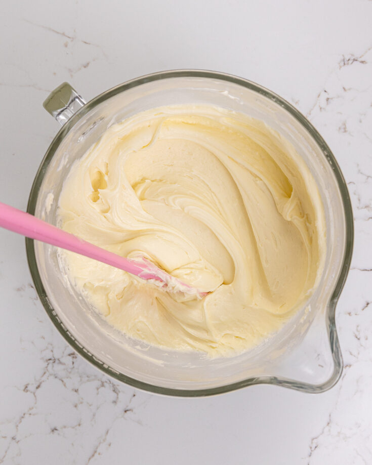 image of white chocolate buttercream that's been mixed in a large glass mixing bowl