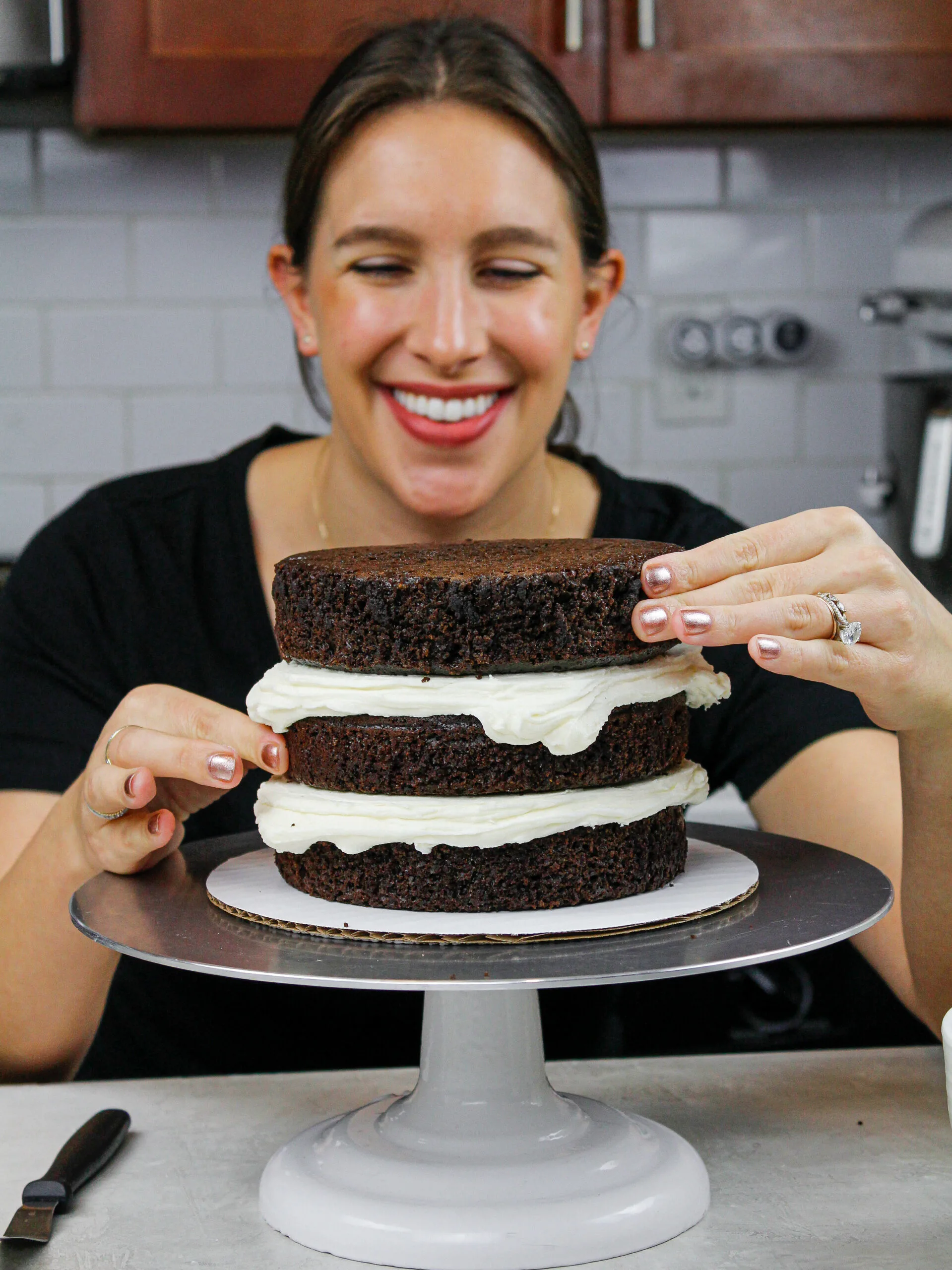 image of chocolate cake layers being stacked by chelsey white of chelsweets