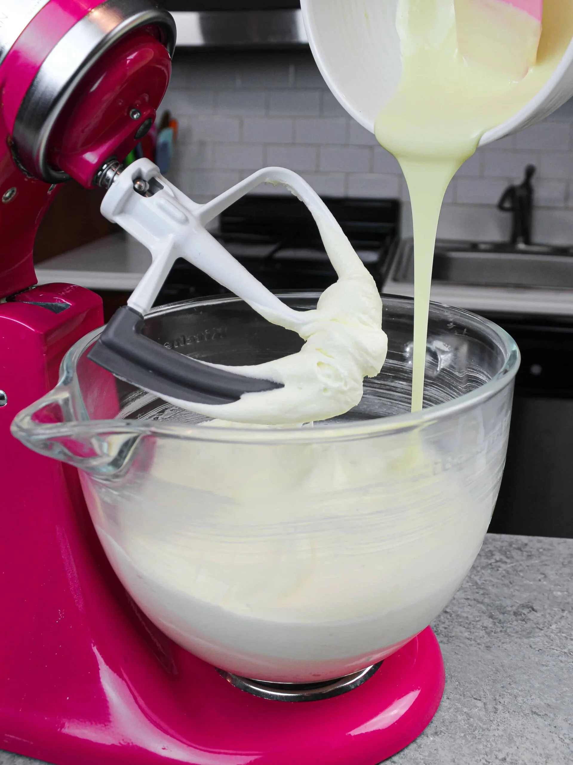 image of melted white chocolate being added into american buttercream to make white chocolate frosting