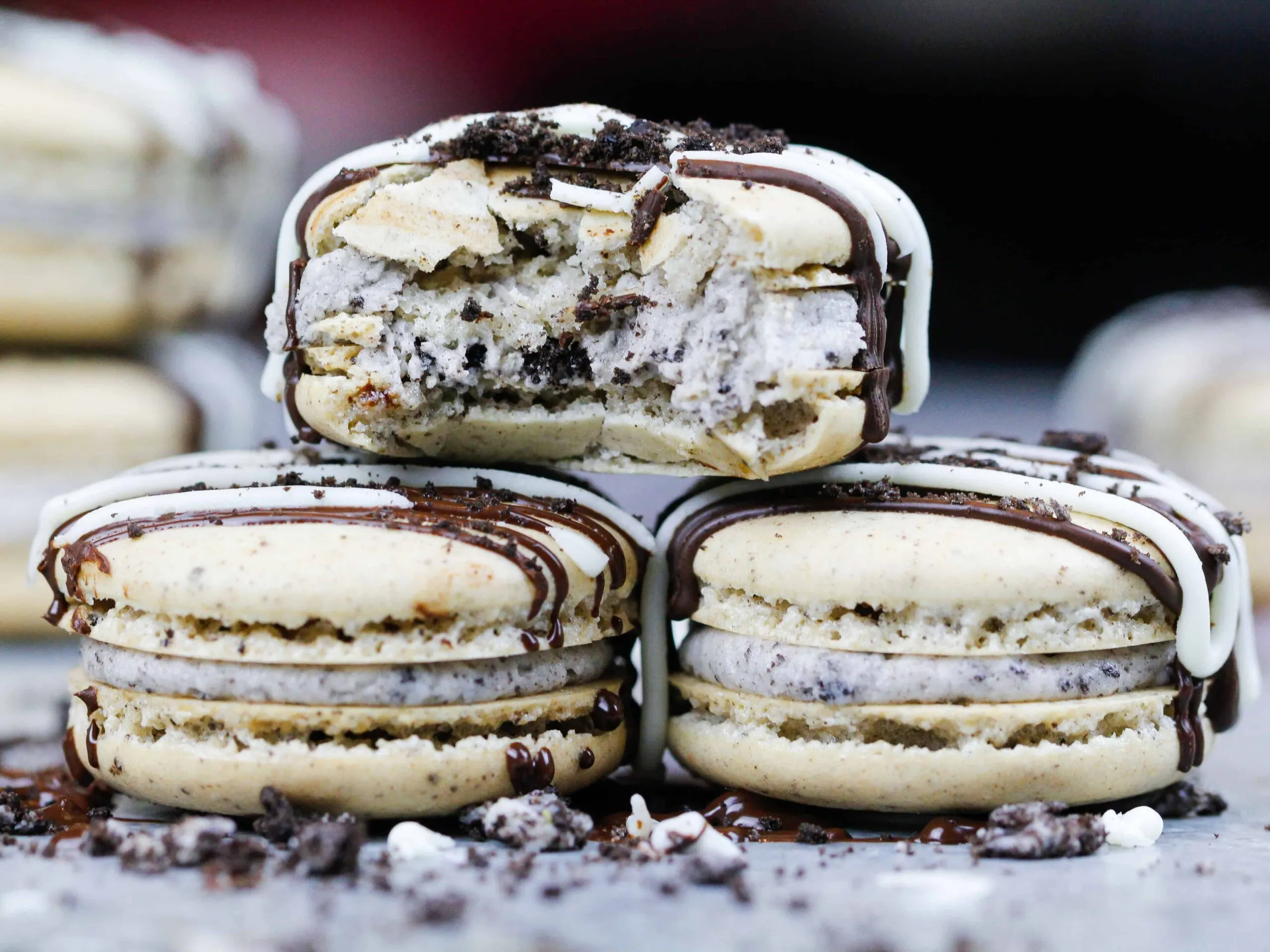 image of oreo macarons that are stacked with one bitten into to show its chewy center