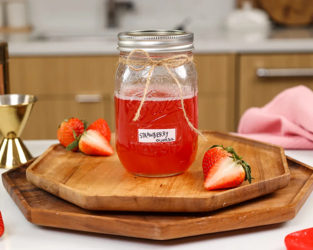 image of strawberry simple syrup in a mason jar