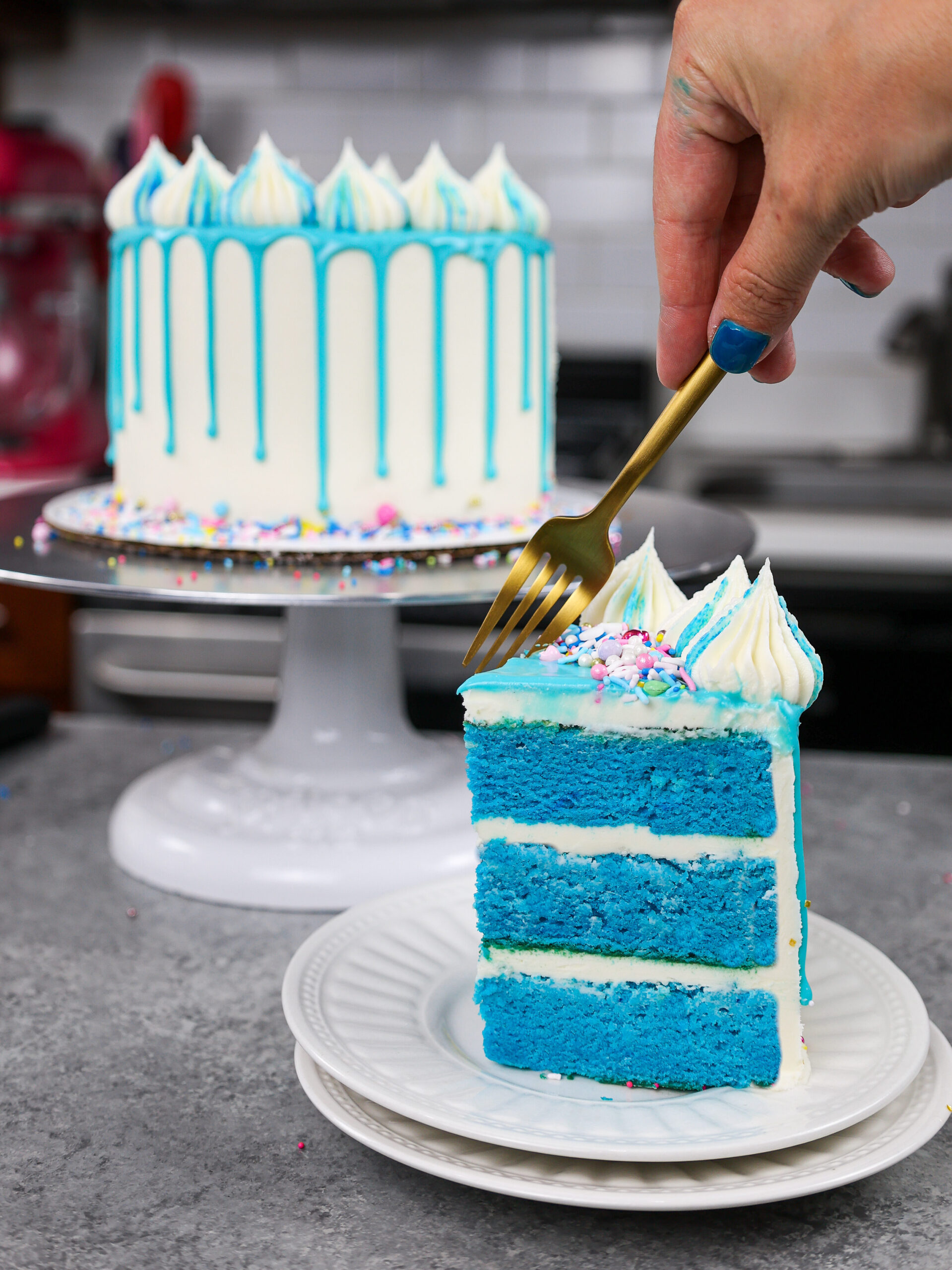 image of a slice of blue cake that's been frosted with american buttercream and decorated with a blue drip