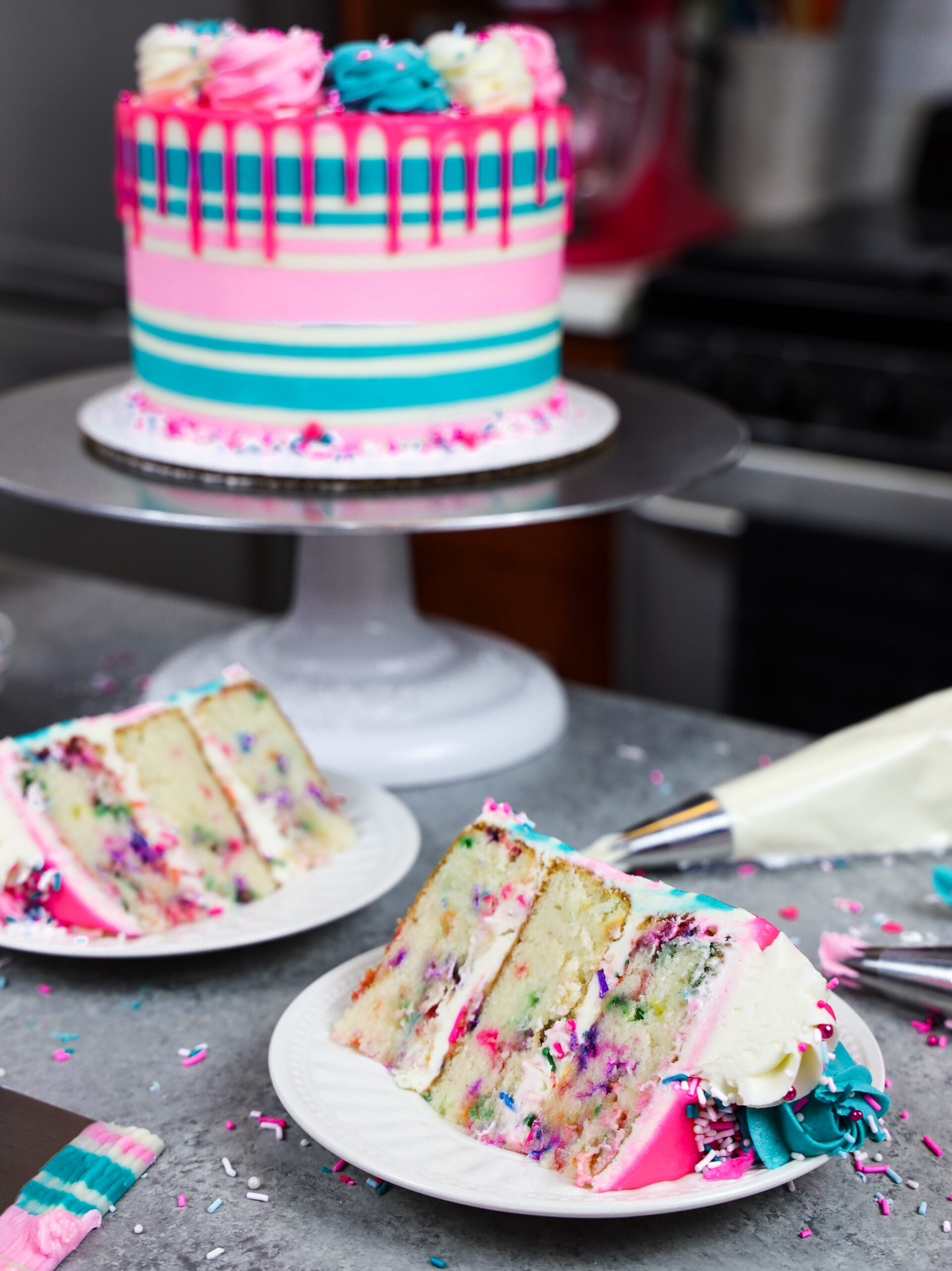 image of slices of a gluten free funfetti cake that's been decorating with buttercream stripes and a pink drip
