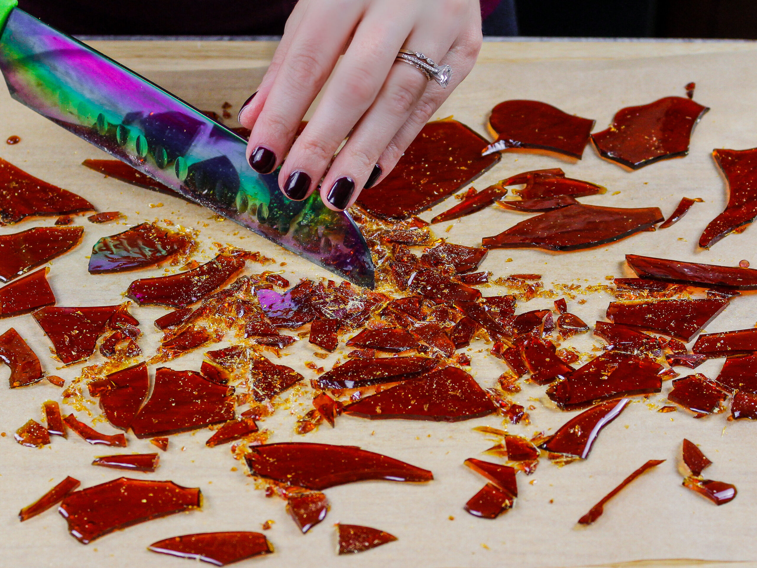 image of caramelized sugar shards being cut into small pieces using a sharp knife