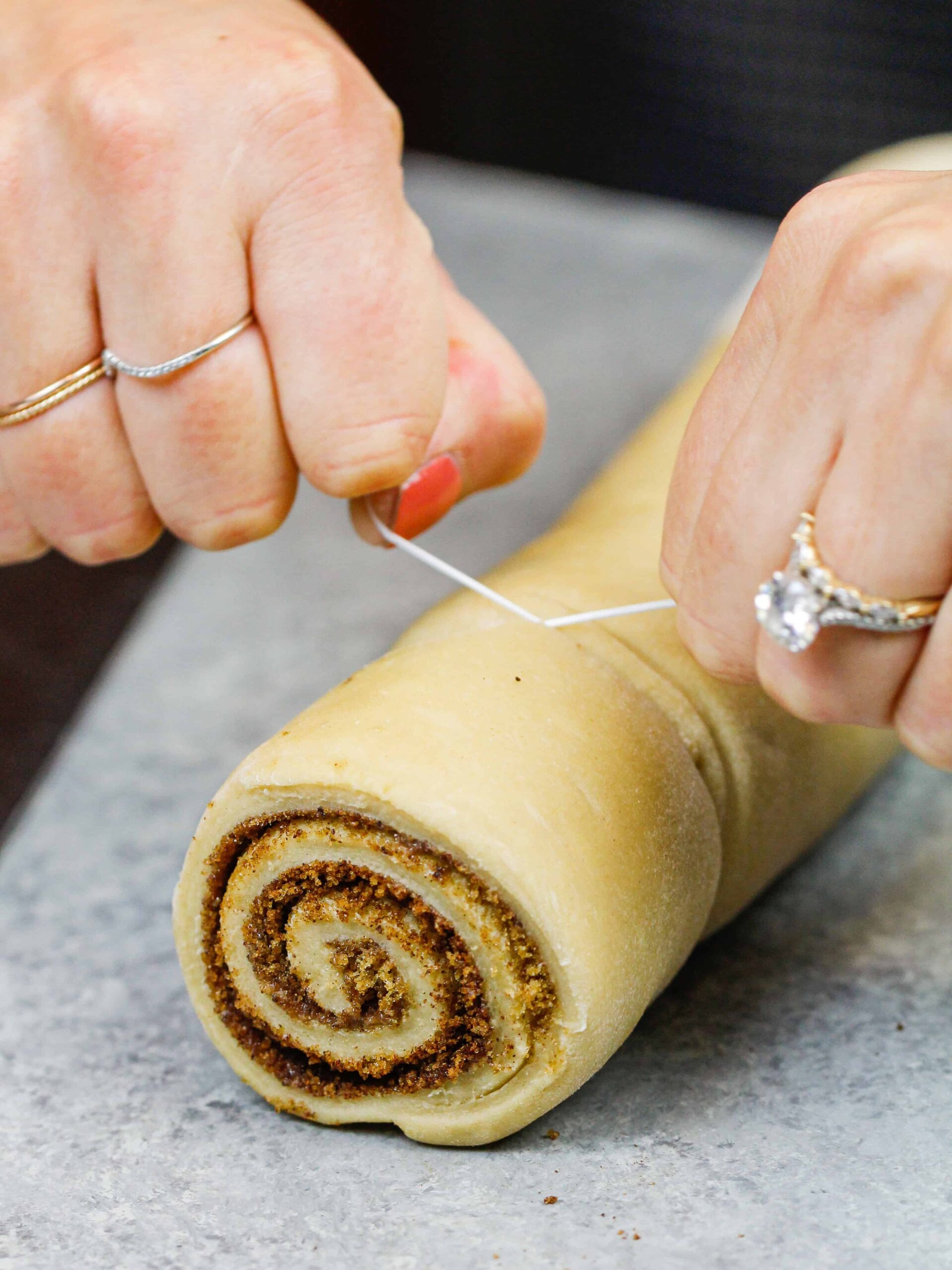 image of quick yeast cinnamon rolls being cut with dental floss