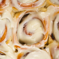 image of frosted quick yeast cinnamon rolls that have been slathered with cream cheese frosting