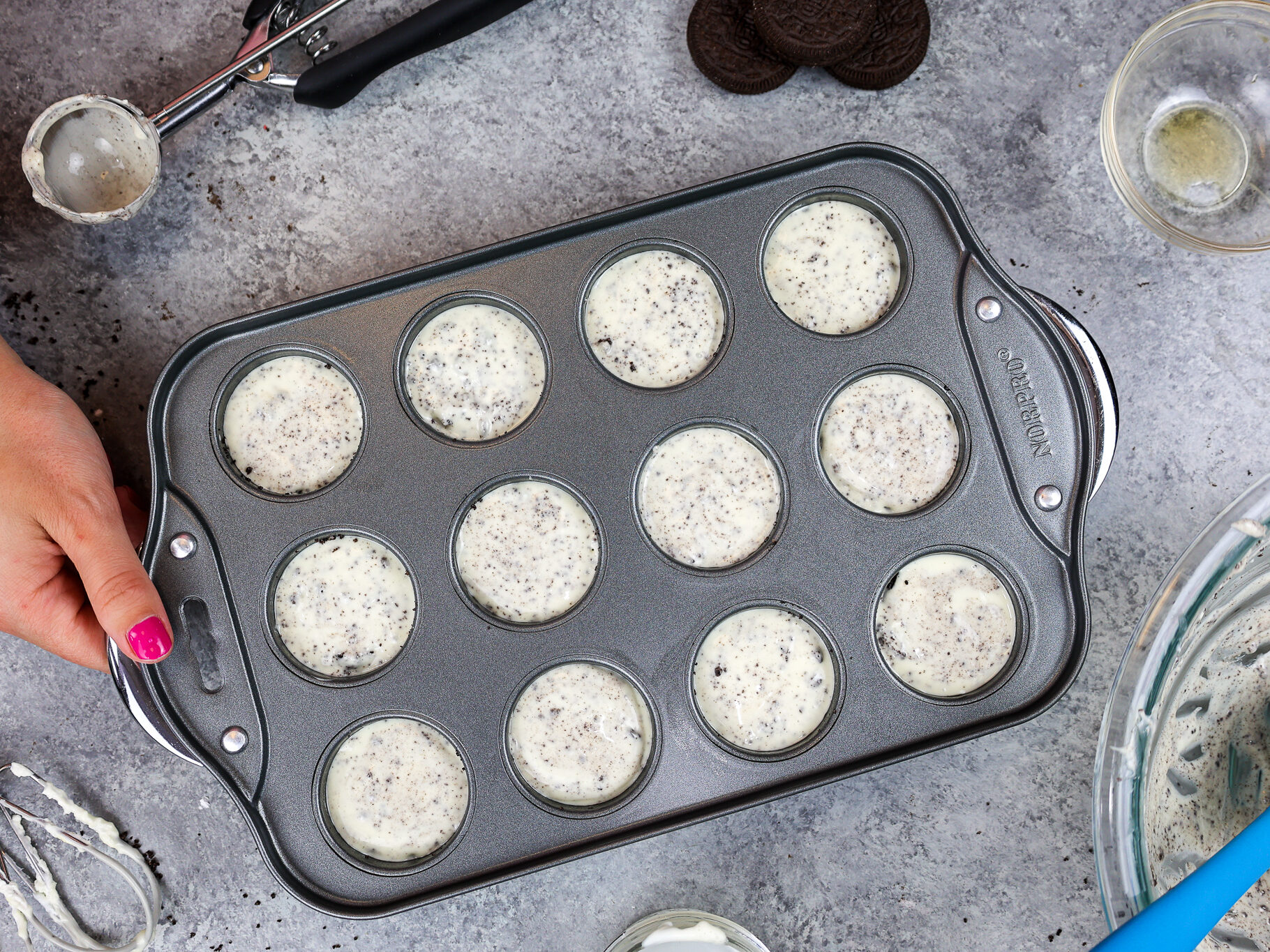 image of mini oreo cheesecakes in a pan ready to be baked