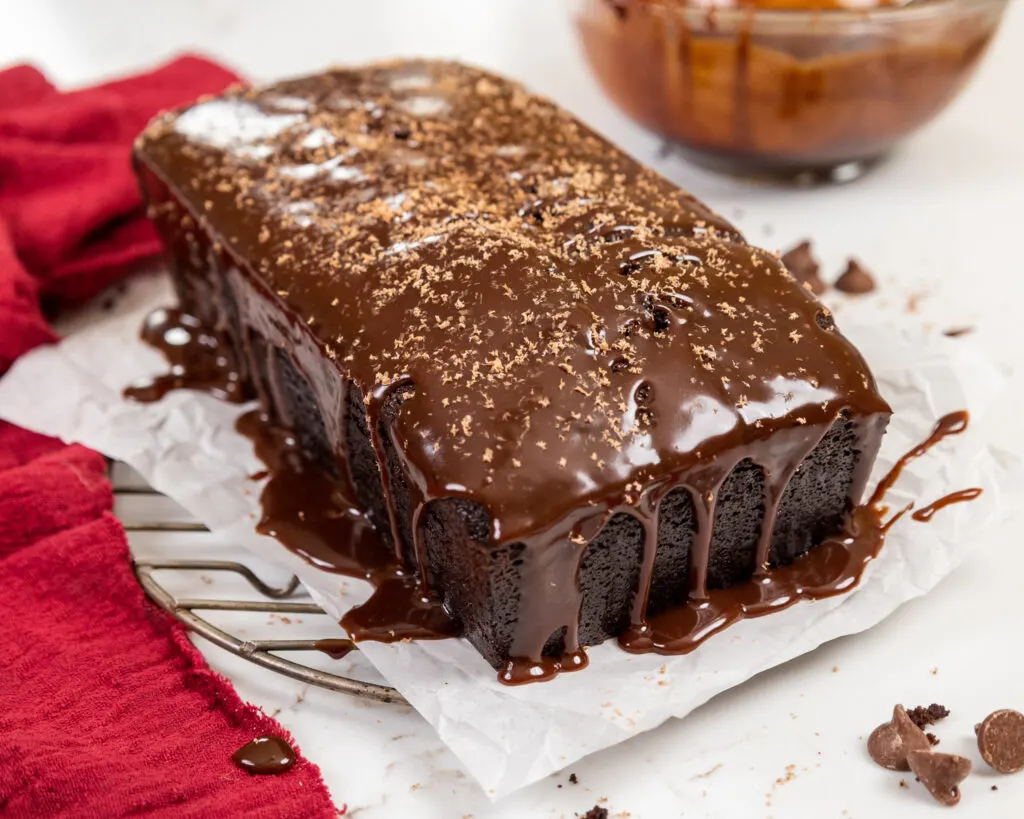 image of a chocolate sour cream pound cake that's been topped with a generous amount of chocolate glaze