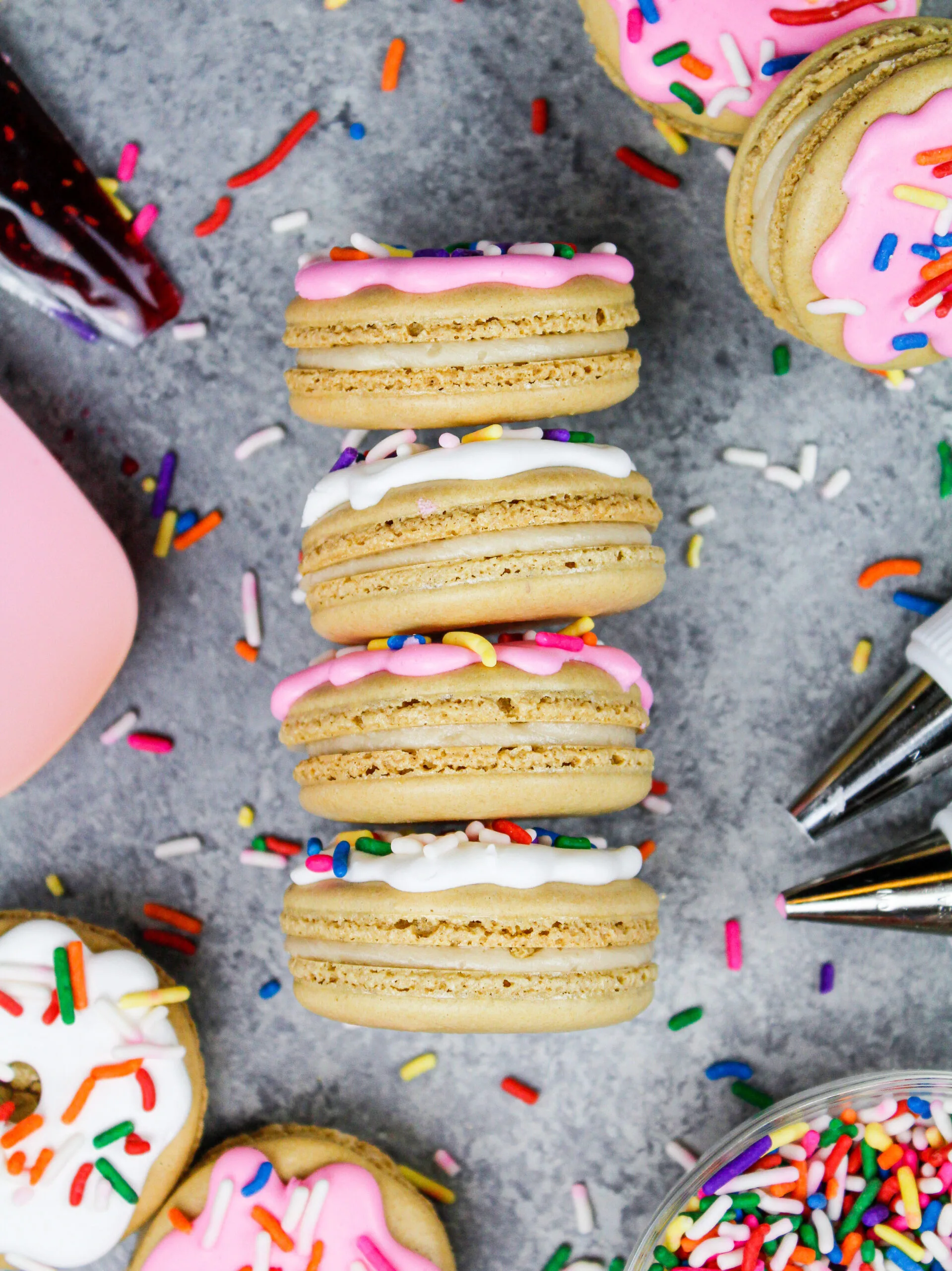 image of donut macarons decorated with royal icing to look just like little frosted sprinkle donuts