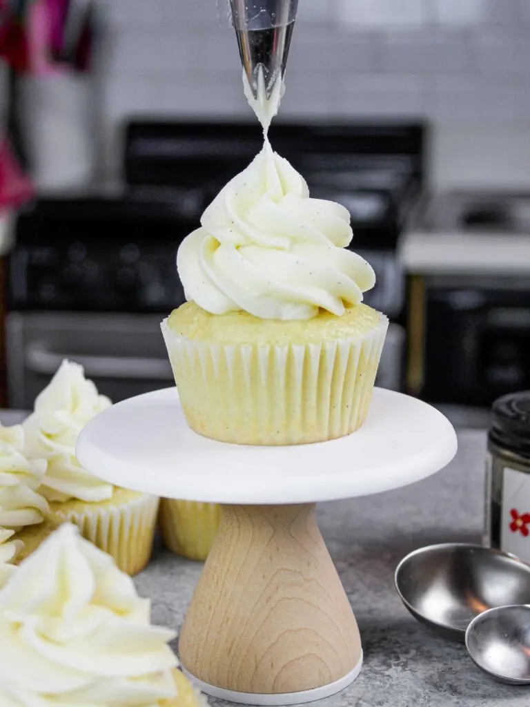 image of gluten free vanilla cupcake being frosted with vanilla bean buttercream