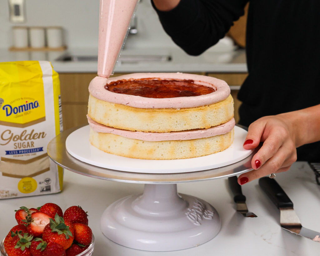 image of a cake being filled with strawberry jam