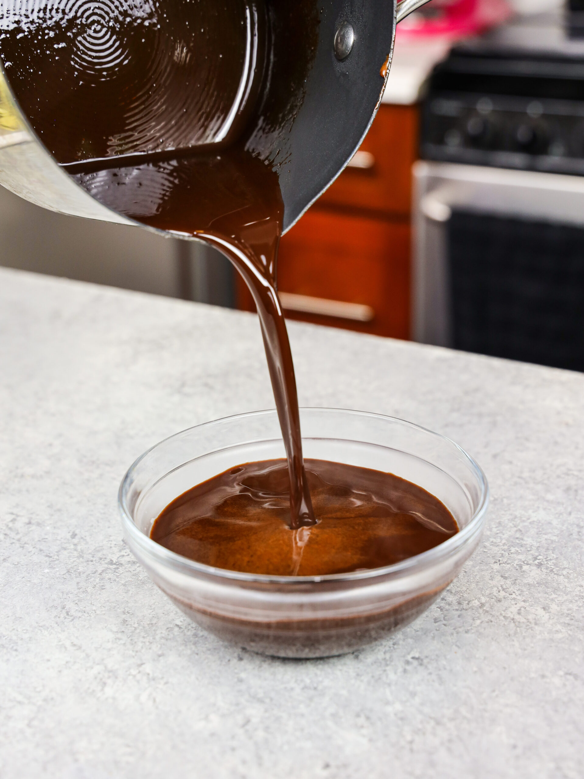 image of chocolate simple syrup being poured into a small bowl to cool